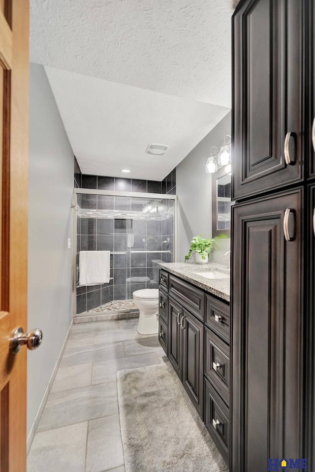 2222 SW Soukup Dr, Lincoln, NE 68522 - bathroom featuring a textured ceiling, a stall shower, toilet, and vanity