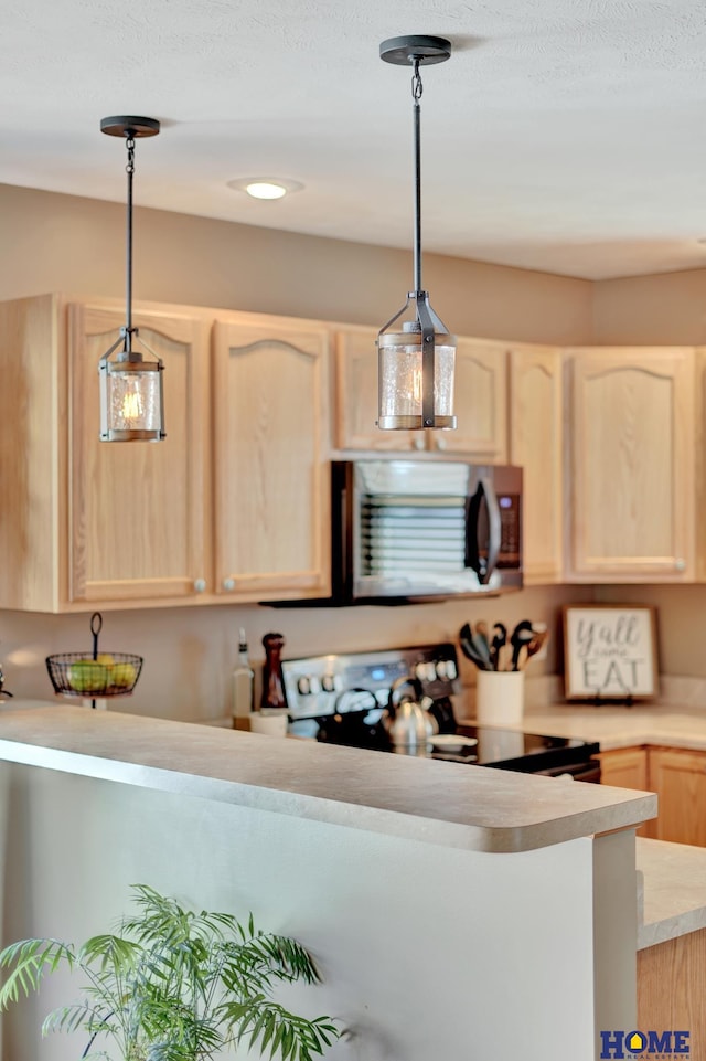 2222 SW Soukup Dr, Lincoln, NE 68522 - kitchen with stainless steel microwave, light brown cabinets, black range with electric stovetop, light countertops, and pendant lighting