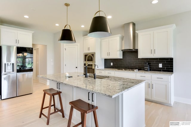 18108 Locust St, Elkhorn, NE 68022 - kitchen with appliances with stainless steel finishes, wall chimney exhaust hood, a sink, light wood-type flooring, and tasteful backsplash