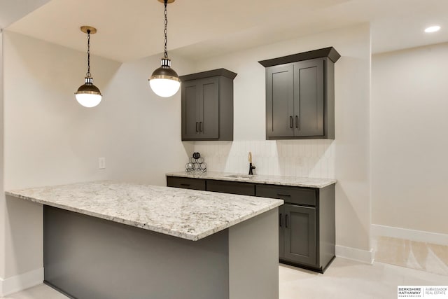 18108 Locust St, Elkhorn, NE 68022 - kitchen with a peninsula, a sink, backsplash, light stone countertops, and hanging light fixtures