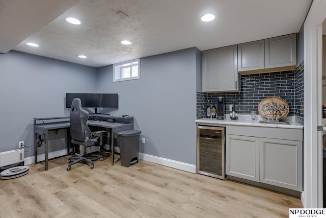 office with wine cooler, baseboards, recessed lighting, light wood finished floors, and a textured ceiling
