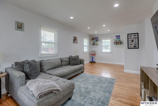 living room featuring light wood finished floors, recessed lighting, and baseboards