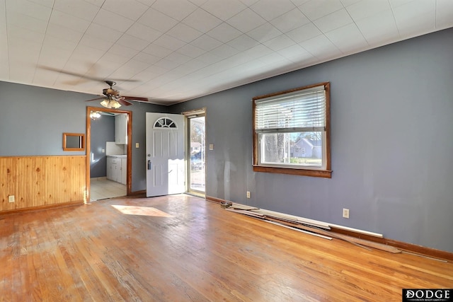 1807 N Platte Ave, Fremont, NE 68025 - unfurnished room featuring hardwood / wood-style flooring, a ceiling fan, a wainscoted wall, wooden walls, and baseboards