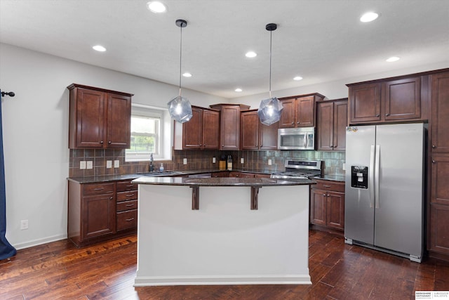 18652 Van Camp Dr, Omaha, NE 68130 - kitchen with stainless steel appliances, a sink, dark wood-style flooring, tasteful backsplash, and recessed lighting