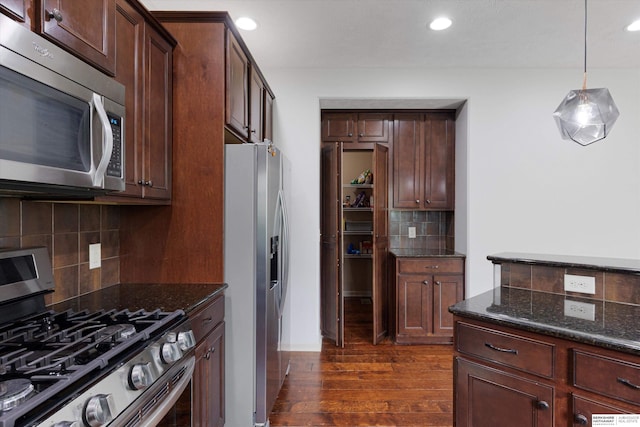 18652 Van Camp Dr, Omaha, NE 68130 - kitchen with appliances with stainless steel finishes, backsplash, dark wood-style floors, dark stone counters, and recessed lighting