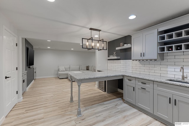 18652 Van Camp Dr, Omaha, NE 68130 - kitchen featuring open shelves, a sink, light wood finished floors, recessed lighting, and backsplash