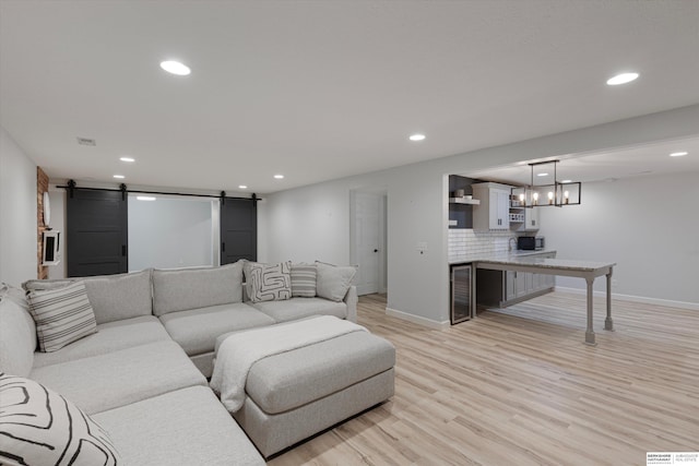 18652 Van Camp Dr, Omaha, NE 68130 - living area featuring a barn door, light wood-type flooring, recessed lighting, and baseboards
