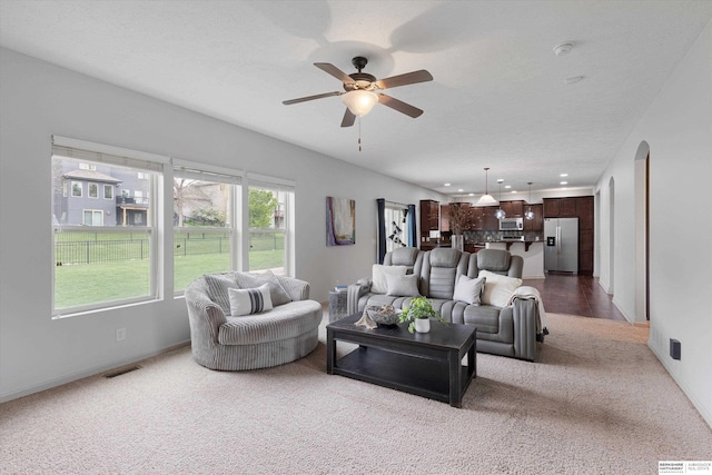 18652 Van Camp Dr, Omaha, NE 68130 - carpeted living room with arched walkways, ceiling fan, and recessed lighting