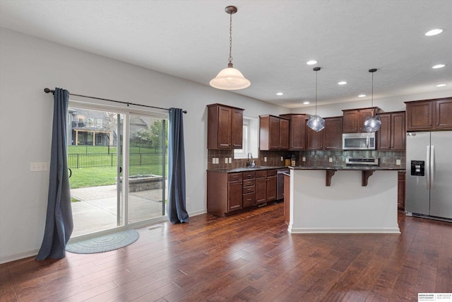 18652 Van Camp Dr, Omaha, NE 68130 - kitchen with stainless steel appliances, a sink, tasteful backsplash, a breakfast bar area, and recessed lighting