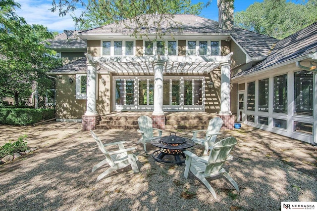 1125 Stone Creek Dr, Blair, NE 68008 - rear view of house featuring a fire pit, a pergola, a chimney, a patio, and stucco siding