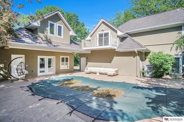 1125 Stone Creek Dr, Blair, NE 68008 - rear view of house featuring french doors, stucco siding, a balcony, an outdoor living space, and a covered pool