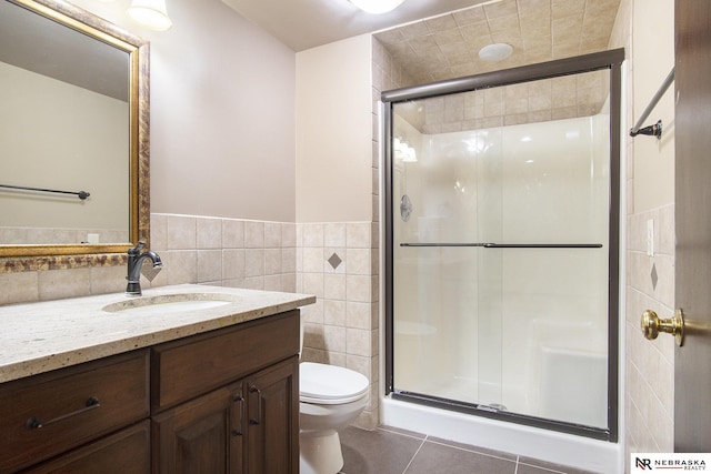 1125 Stone Creek Dr, Blair, NE 68008 - bathroom featuring tile walls, toilet, tile patterned flooring, a shower stall, and vanity