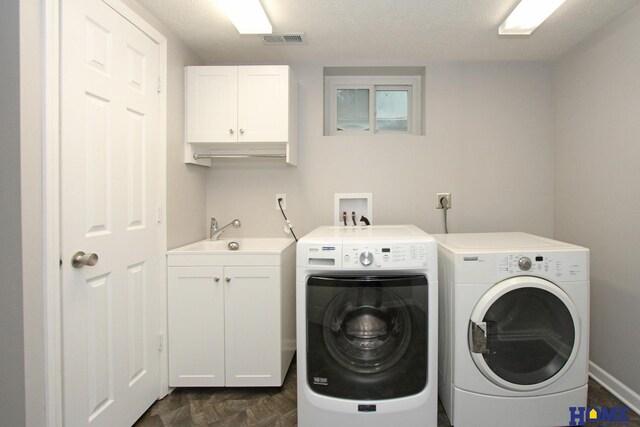 1701 N 73rd St, Lincoln, NE 68505 - laundry area with cabinet space, washing machine and dryer, and a textured ceiling
