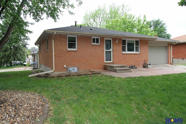 1701 N 73rd St, Lincoln, NE 68505 - back of house with brick siding, a garage, and a lawn