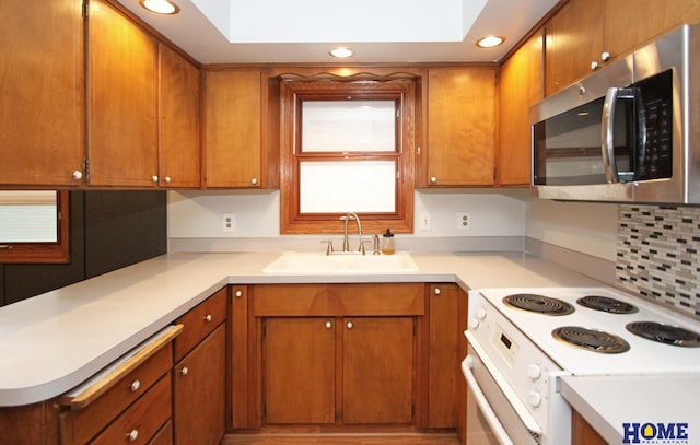 1701 N 73rd St, Lincoln, NE 68505 - kitchen with stainless steel microwave, white electric range oven, a sink, light countertops, and recessed lighting