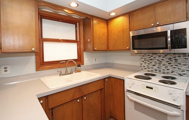 1701 N 73rd St, Lincoln, NE 68505 - kitchen with white range with electric stovetop, stainless steel microwave, a sink, light countertops, and recessed lighting