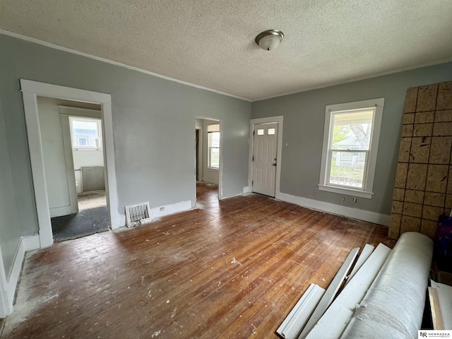 1300 Claremont St, Lincoln, NE 68508 - unfurnished living room with ornamental molding, healthy amount of natural light, wood-type flooring, and a textured ceiling
