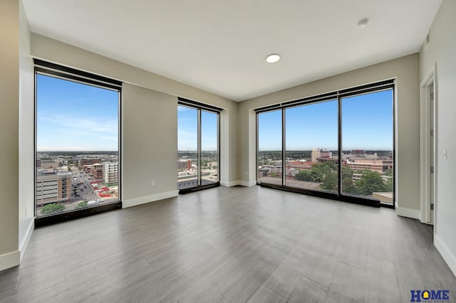 1125 Q St Unit 1401, Lincoln, NE 68508 - spare room with baseboards, a city view, and wood finished floors