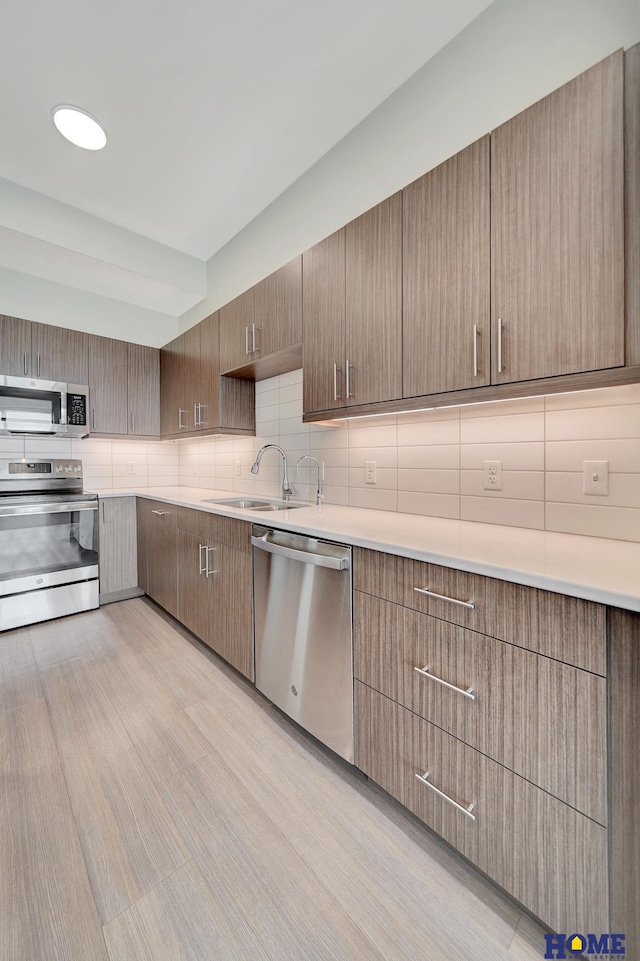 1125 Q St Unit 1401, Lincoln, NE 68508 - kitchen featuring appliances with stainless steel finishes, a sink, decorative backsplash, and light countertops