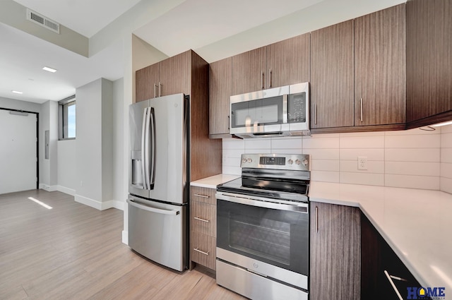 1125 Q St Unit 1401, Lincoln, NE 68508 - kitchen featuring appliances with stainless steel finishes, light countertops, and decorative backsplash
