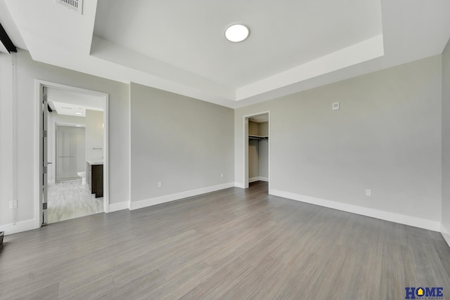 1125 Q St Unit 1401, Lincoln, NE 68508 - spare room with a tray ceiling, baseboards, and wood finished floors
