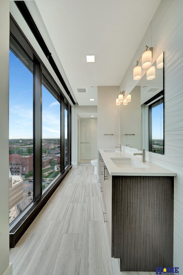1125 Q St Unit 1401, Lincoln, NE 68508 - bathroom featuring double vanity, plenty of natural light, and toilet