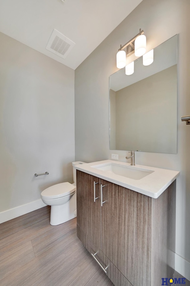 1125 Q St Unit 1401, Lincoln, NE 68508 - bathroom featuring toilet, vanity, wood finished floors, and baseboards