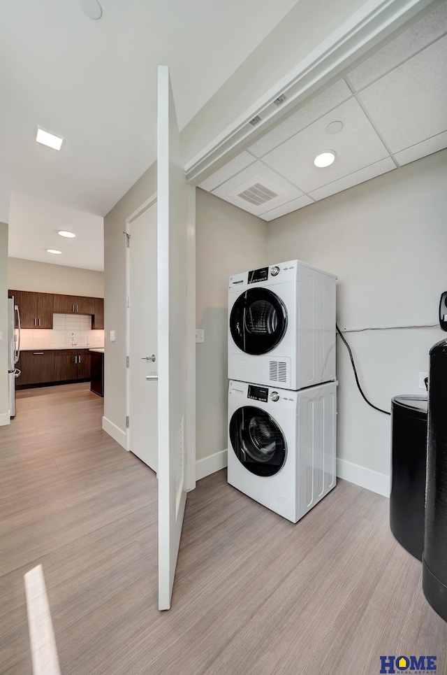 1125 Q St Unit 1401, Lincoln, NE 68508 - laundry room featuring stacked washer / drying machine, light wood-type flooring, and baseboards