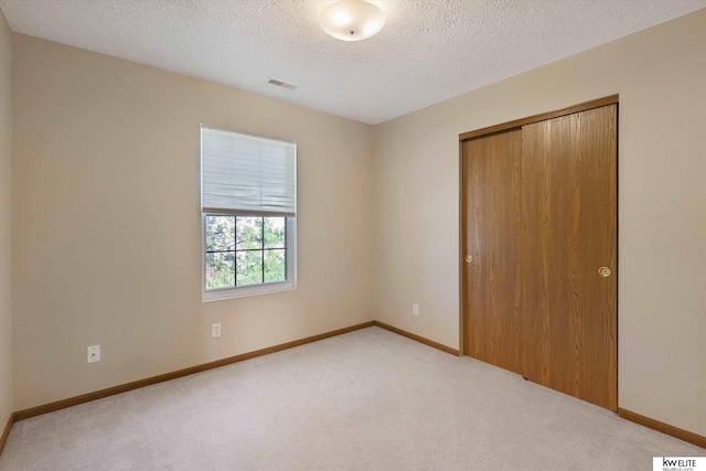 3909 N 147th St, Omaha, NE 68116 - unfurnished bedroom with light carpet, a closet, a textured ceiling, and baseboards