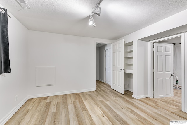 221 Lindale Cir, Hickman, NE 68372 - unfurnished bedroom featuring light wood-style floors, a textured ceiling, and baseboards