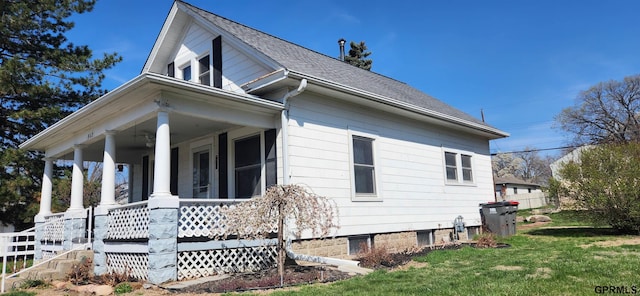 942 Manatt St, Lincoln, NE 68521 - view of side of property with covered porch, a lawn, and a shingled roof