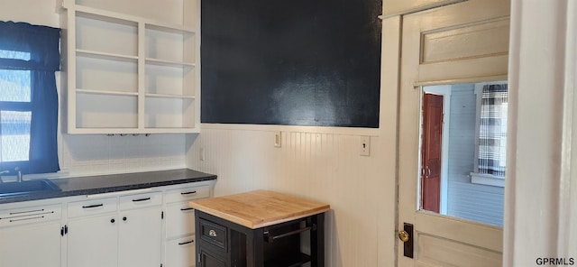 942 Manatt St, Lincoln, NE 68521 - kitchen with a wainscoted wall, white cabinets, open shelves, and a sink