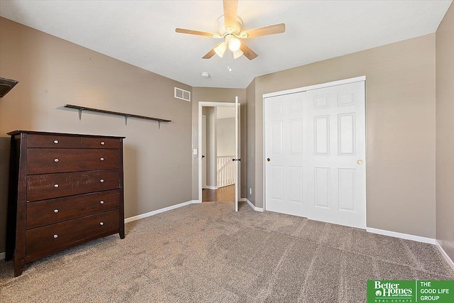 unfurnished bedroom with baseboards, light carpet, a ceiling fan, and a closet