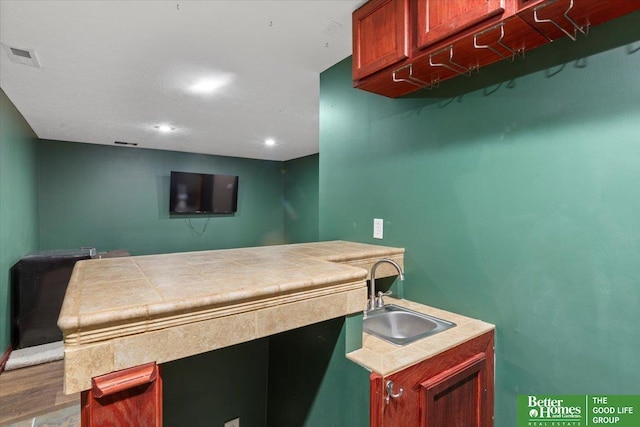 bar area featuring a sink, recessed lighting, and wood finished floors