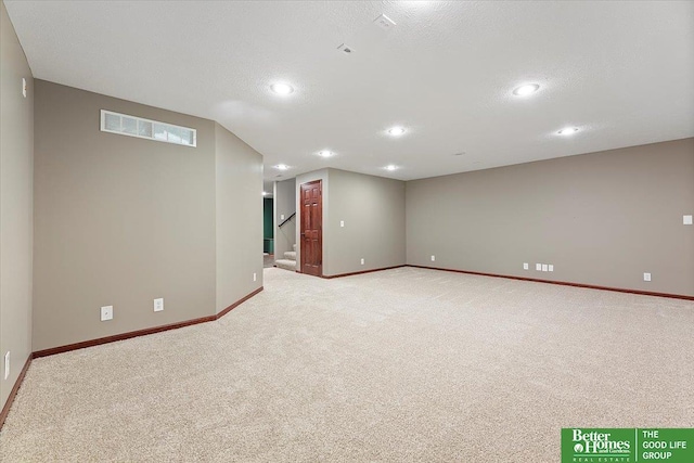 basement with light carpet, baseboards, recessed lighting, stairs, and a textured ceiling
