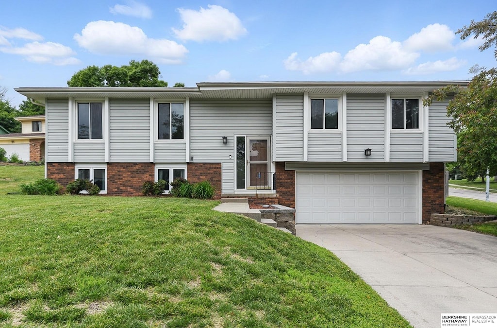 2908 S 160th Cir, Omaha, NE 68130 - split foyer home featuring a garage, a front yard, concrete driveway, and brick siding