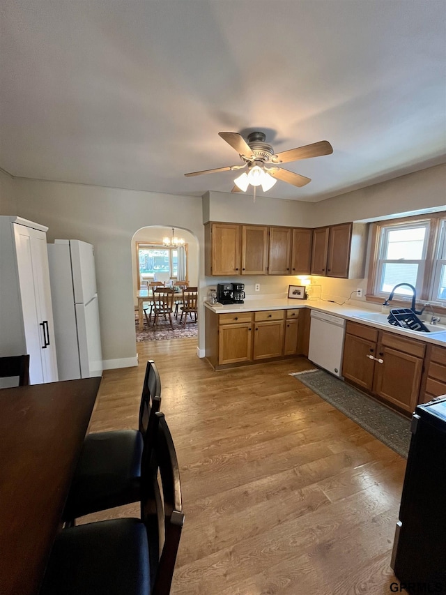 kitchen featuring white appliances, a ceiling fan, light countertops, and light wood-type flooring