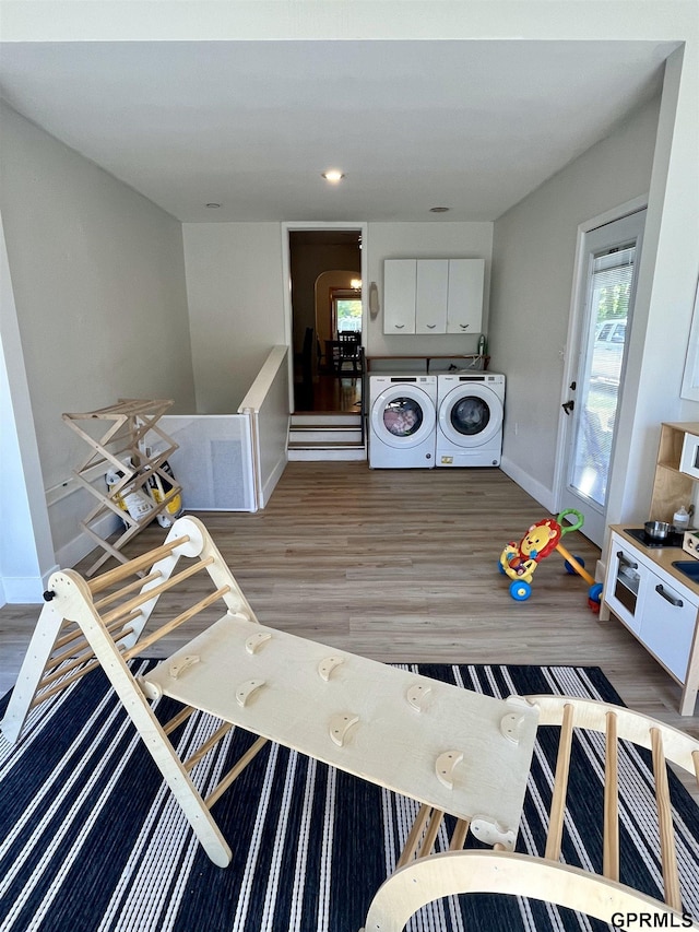 laundry area featuring washer and clothes dryer, light wood-style floors, and baseboards