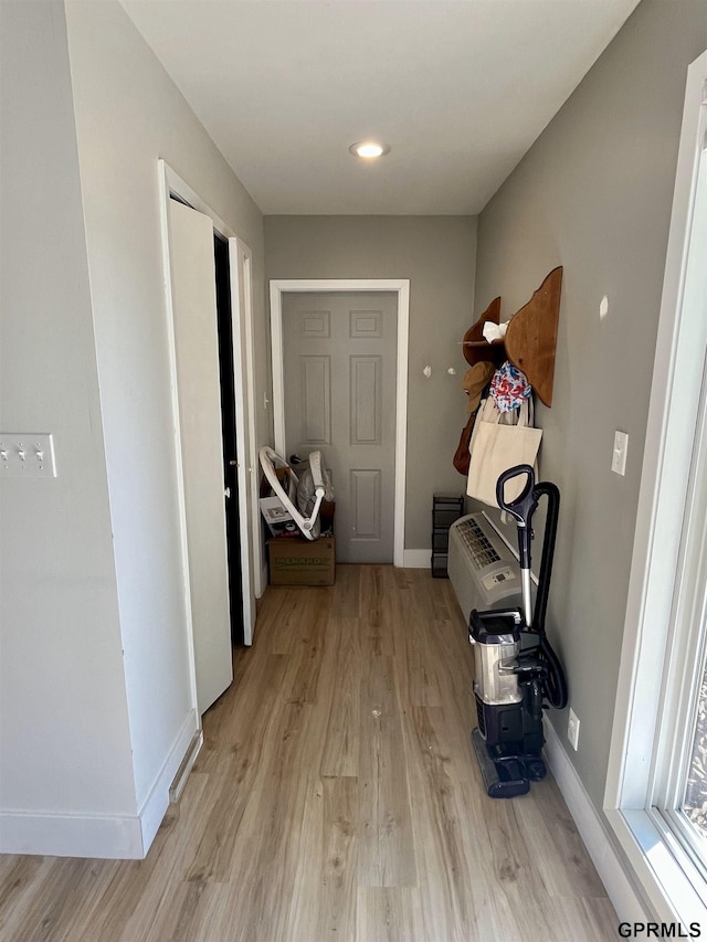 hallway with light wood-type flooring and baseboards