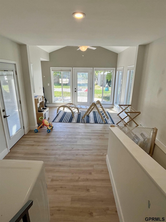 dining space with vaulted ceiling, light wood-type flooring, baseboards, and a ceiling fan