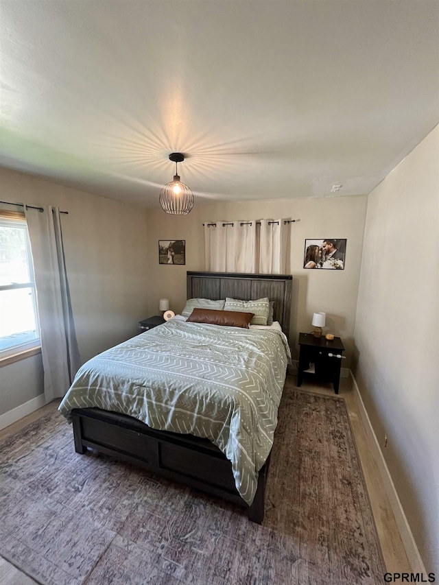 bedroom featuring baseboards and wood finished floors