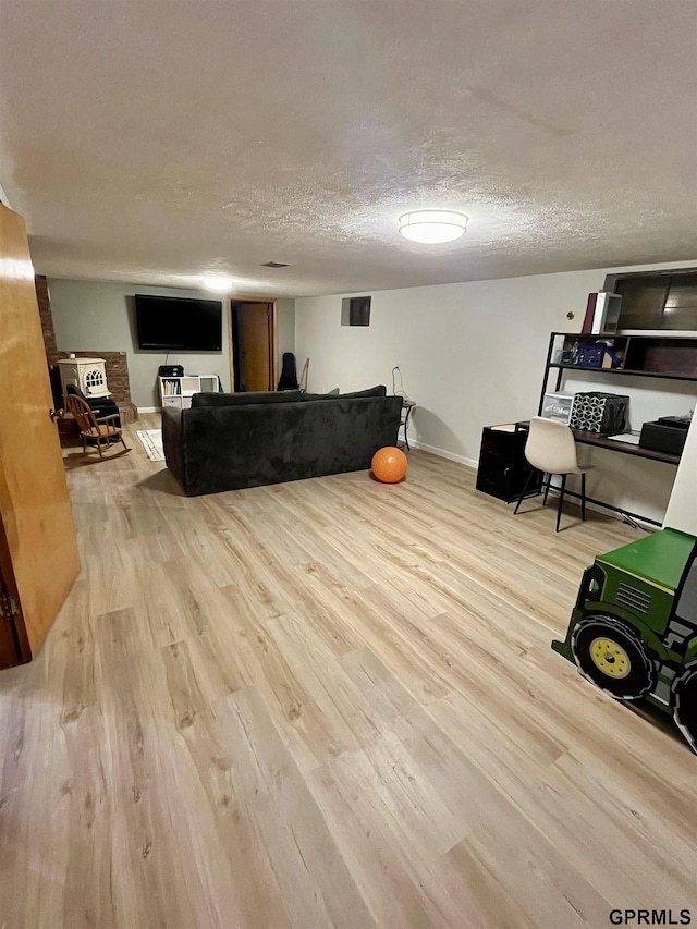 living room featuring wood finished floors, baseboards, and a textured ceiling