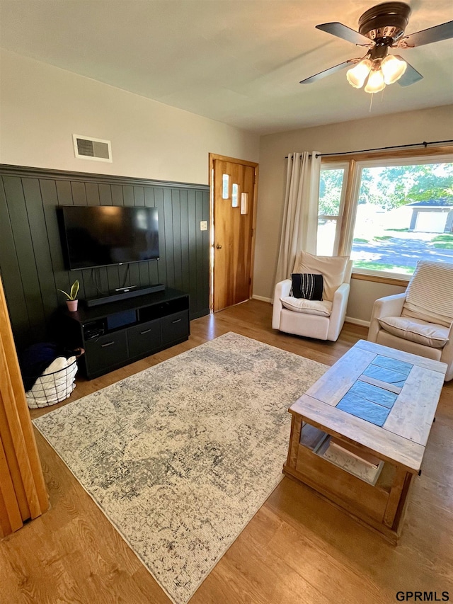 living room with a ceiling fan, wood finished floors, and baseboards
