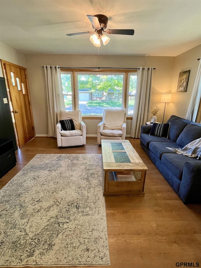 living area featuring ceiling fan, wood finished floors, and baseboards