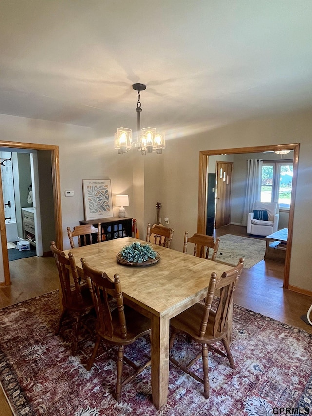 dining area with a chandelier and wood finished floors