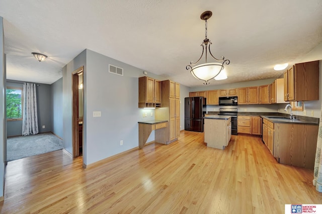 7910 Red Oak Rd, Lincoln, NE 68516 - kitchen featuring black appliances, a sink, light wood finished floors, dark countertops, and a kitchen island