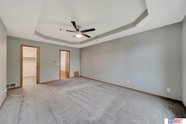 7910 Red Oak Rd, Lincoln, NE 68516 - unfurnished bedroom with a tray ceiling, a spacious closet, baseboards, carpet, and ceiling fan