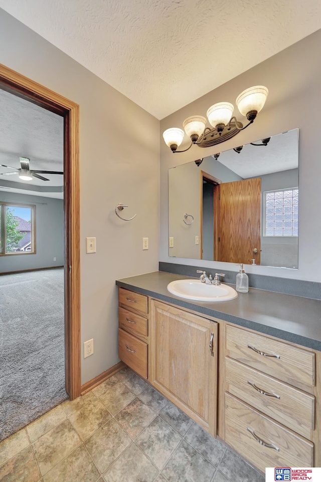 7910 Red Oak Rd, Lincoln, NE 68516 - bathroom with plenty of natural light, vanity, baseboards, a textured ceiling, and ceiling fan