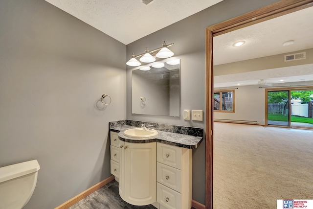 7910 Red Oak Rd, Lincoln, NE 68516 - half bath with vanity, toilet, baseboards, a baseboard radiator, and a textured ceiling