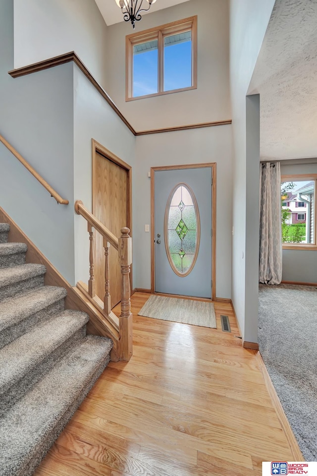 7910 Red Oak Rd, Lincoln, NE 68516 - foyer entrance featuring a towering ceiling, stairway, wood finished floors, baseboards, and a chandelier